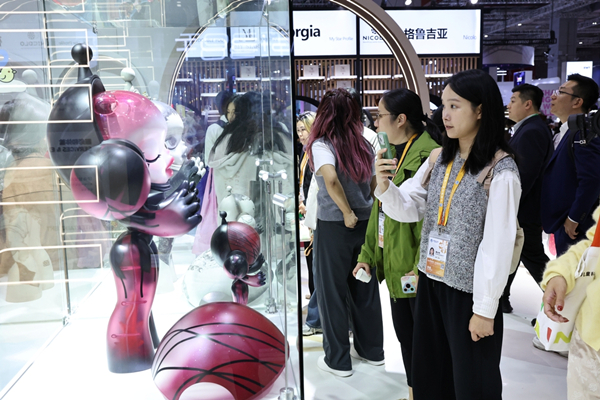 一位参观者在周四在上海举办的第八届中国国际进口博览会消费品展览区的 Pop Mart 展位前拍摄展品.jpg