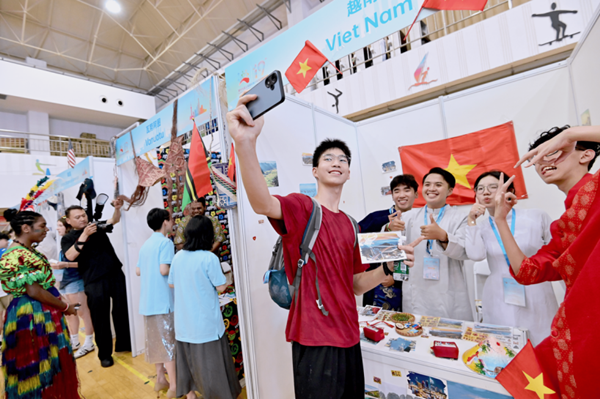 一名中国学生在越南展台与越南营员们合影自拍.png